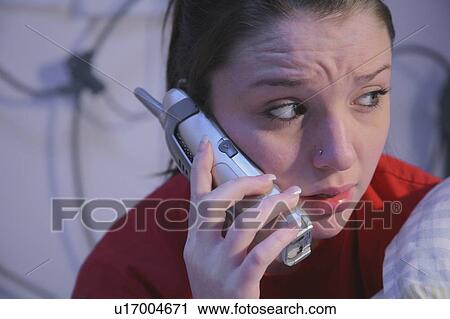 Stock Image - Worried teenage girl on the phone. Fotosearch