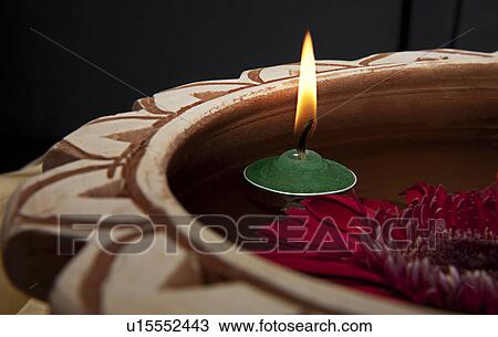 Stock Image - A pink flower and a candle. Fotosearch