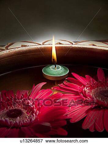 Stock Photo - A pink flower and a candle. Fotosearch