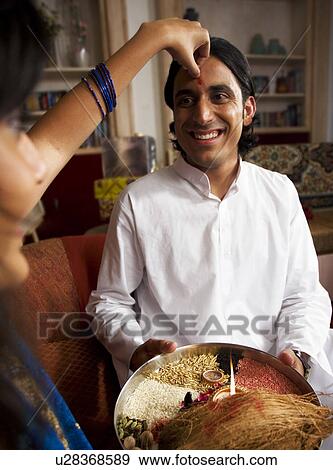 Stock Photo - Applying tika on Rakshabandhan. Fotosearch