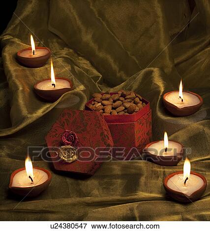 Stock Photo - Box with nuts and diyas. Fotosearch