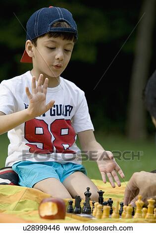 Boy playing chess at a picnic View Large Photo Image Stock Photograph - Boy playing chess at a picnic. Fotosearch