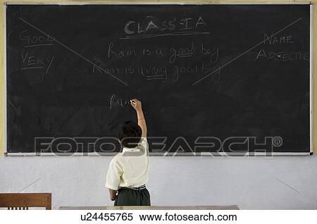 Stock Photography - Boy writing on a black board . Fotosearch