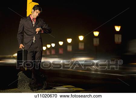 Stock Image - Businessman waiting on the footpath. Fotosearch