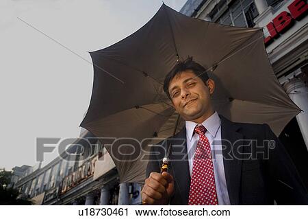 Stock Image - Businessman with an umbrella. Fotosearch