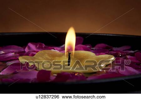 Stock Photograph - Candle with flower petals. Fotosearch