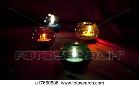 Stock Photograph - Candles in colourful glass jars. Fotosearch