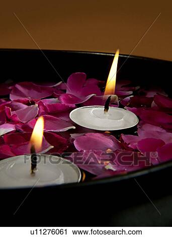 Stock Image - Candles with flower petals. Fotosearch