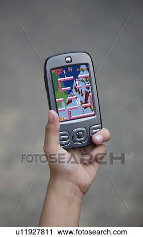 Stock Image - Child holding a mobile phone. Fotosearch