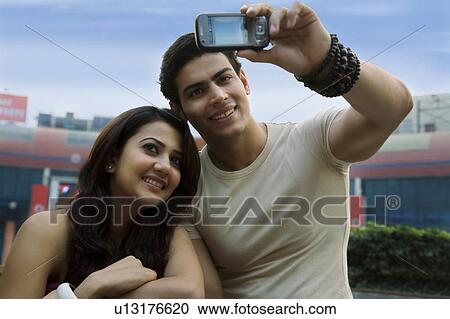 Stock Image - Couple clicking their photograph. Fotosearch