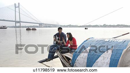 Couple enjoying on a boat View Large Photo Image Stock Photo - Couple enjoying on a boat. Fotosearch
