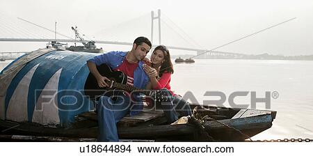 Picture - Couple looking at a phone. Fotosearch