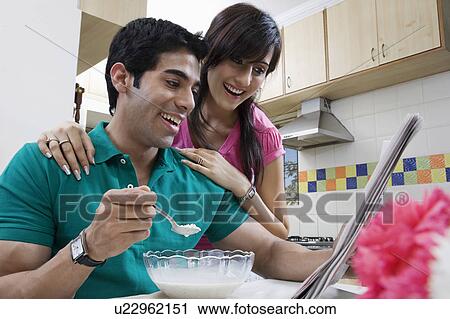 Stock Image - Couple looking at the morning newspaper. Fotosearch