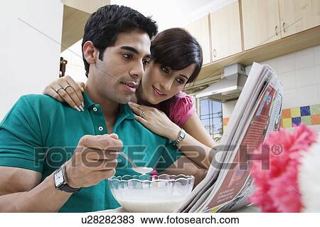 Couple looking at the morning newspaper View Large Photo Image Stock Image - Couple looking at the morning newspaper. Fotosearch