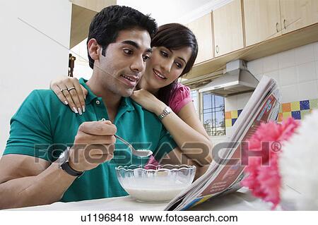 Couple looking at the morning newspaper View Large Photo Image Stock Photo - Couple looking at the morning newspaper. Fotosearch