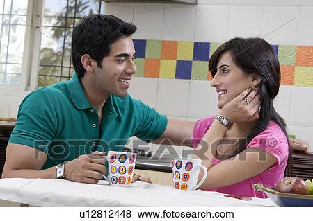 Stock Photo - Couple sitting in the kitchen. Fotosearch