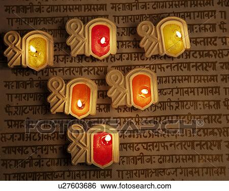 Stock Photograph - Decorative diyas on a script. Fotosearch