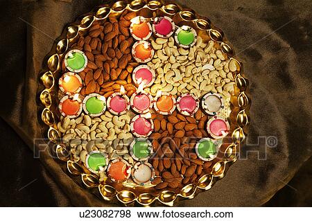 Stock Photo - Different types of nuts with diyas. Fotosearch
