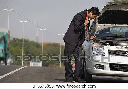 Executive stranded with a broken down car View Large Photo Image Stock Photography - Executive stranded with a broken down car. Fotosearch