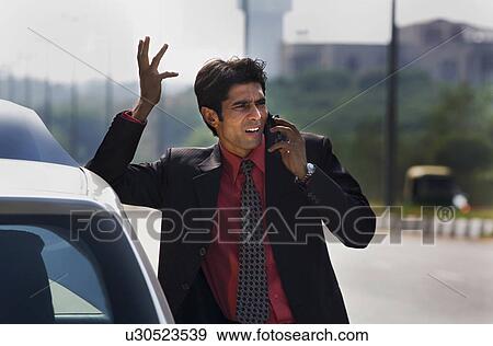 Stock Photo - Executive talking on the mobile phone. Fotosearch