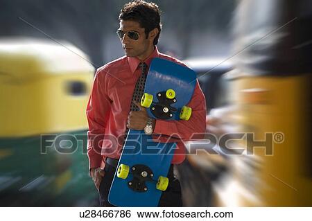 Stock Photograph - Executive with a skateboard. Fotosearch