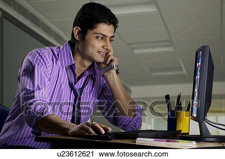 Stock Image - Executive working at his desk. Fotosearch