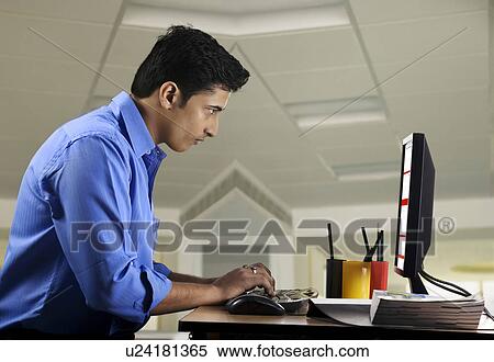 Stock Photography - Executive working at his desk. Fotosearch