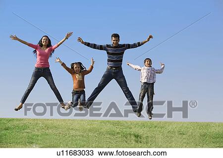 Stock Image - Family jumping in the air. Fotosearch