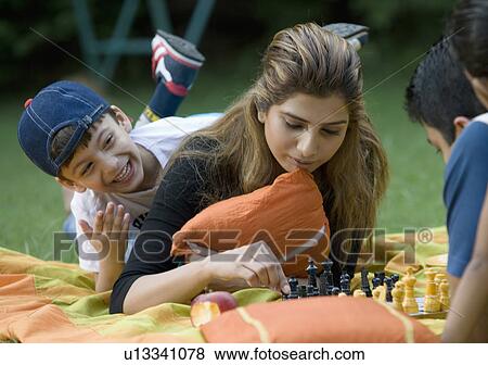 Stock Photo - Family playing chess at picnic. Fotosearch