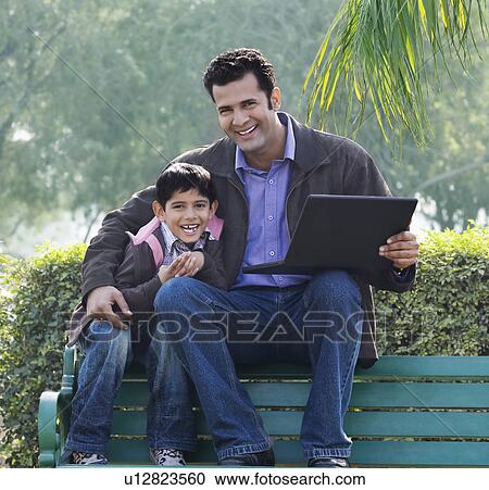 Stock Image - Father and son in a park. Fotosearch