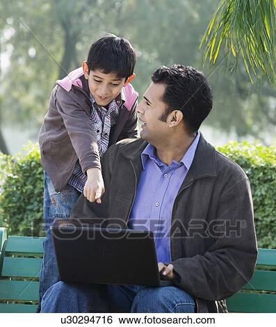 Father and son in a park View Large Photo Image Stock Photograph - Father and son in a park. Fotosearch