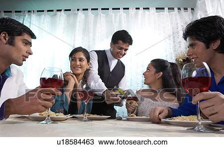 Stock Image - Friends enjoying a meal . Fotosearch