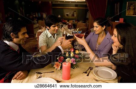 Stock Image - Friends enjoying a meal. Fotosearch
