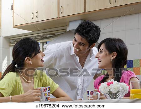 Picture - Friends having coffee in the kitchen. Fotosearch