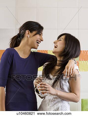Stock Image - Friends having fun in the kitchen. Fotosearch