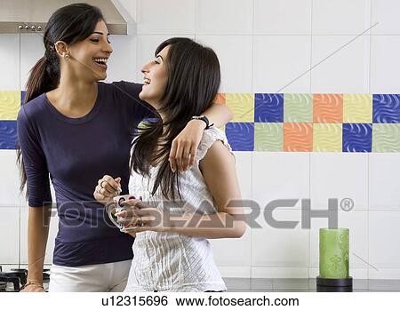 Stock Photograph - Friends having fun in the kitchen. Fotosearch