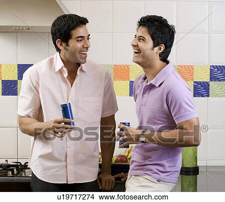 Picture - Friends laughing in the kitchen. Fotosearch