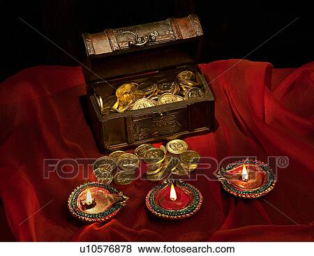 Stock Photo - Gold coins and diyas. Fotosearch