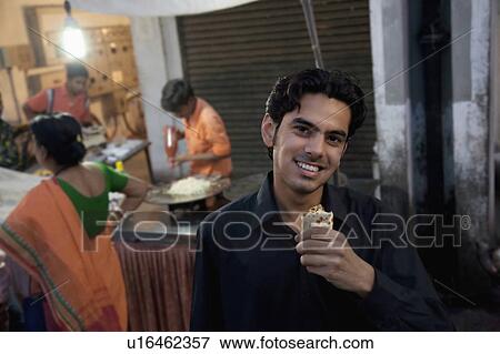 Man eating street food View Large Photo Image Stock Photo - Man eating street food. Fotosearch