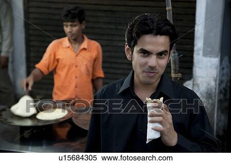Stock Photography - Man eating street food. Fotosearch