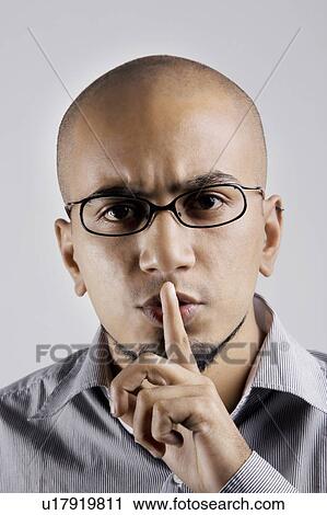 Stock Image - Man gesturing to be quiet. Fotosearch