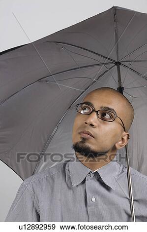 Stock Photo - Man holding an umbrella. Fotosearch