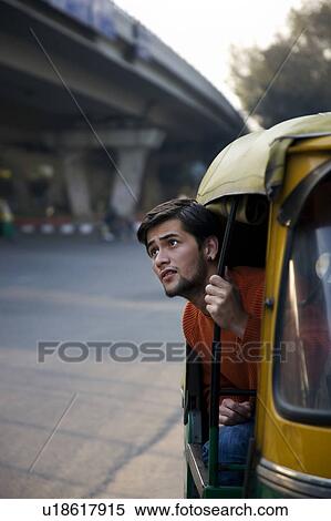 Stock Photography - Man looking out of an autorickshaw. Fotosearch