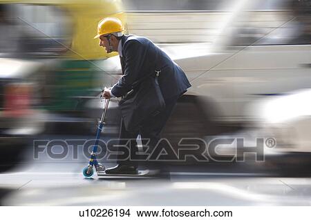 Picture - Man on a toy scooter. Fotosearch