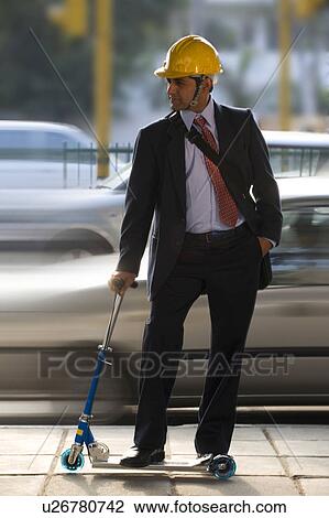 Stock Image - Man on a toy scooter. Fotosearch
