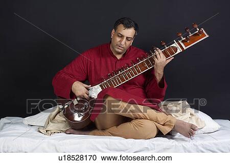 Stock Image - Man playing the sitar. Fotosearch