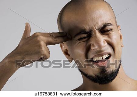Stock Image - Man pretending to shoot himself. Fotosearch