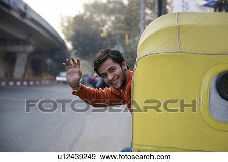 Stock Photo - Man waving from an autorickshaw. Fotosearch