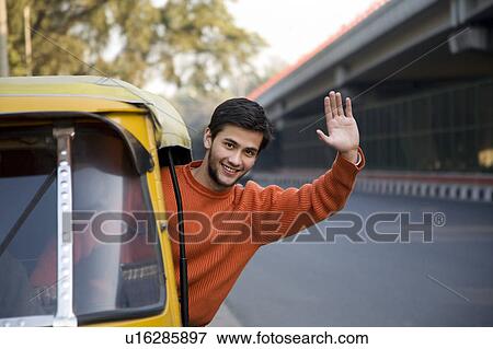 Stock Photo - Man waving from an autorickshaw. Fotosearch