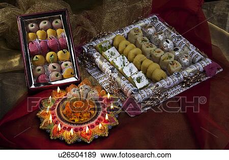 Stock Photo - Sweet dishes with diyas. Fotosearch
